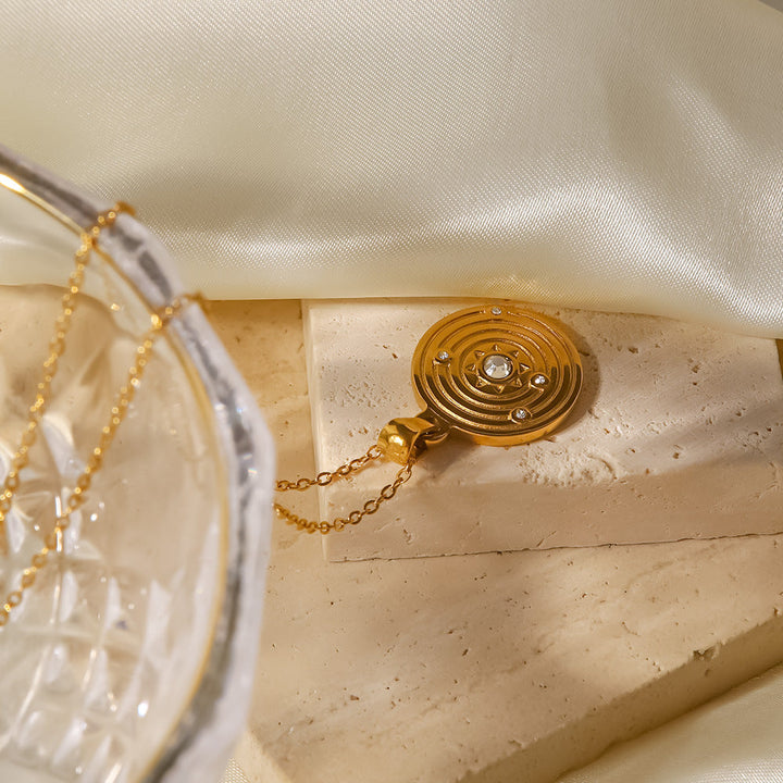 Alžběta – Collar dorado con pequeños colgantes simbólicos.