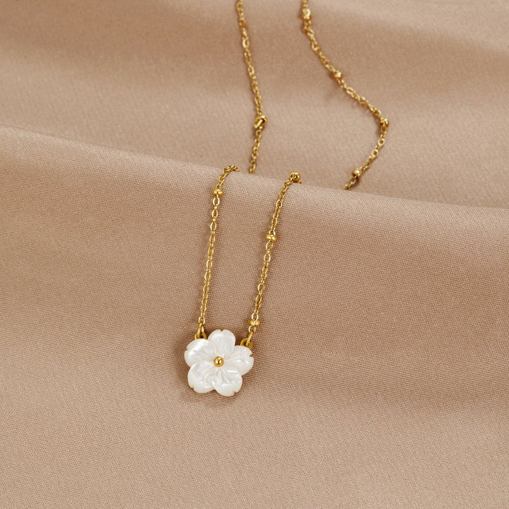 Alena – Collar dorado con colgante de flor.